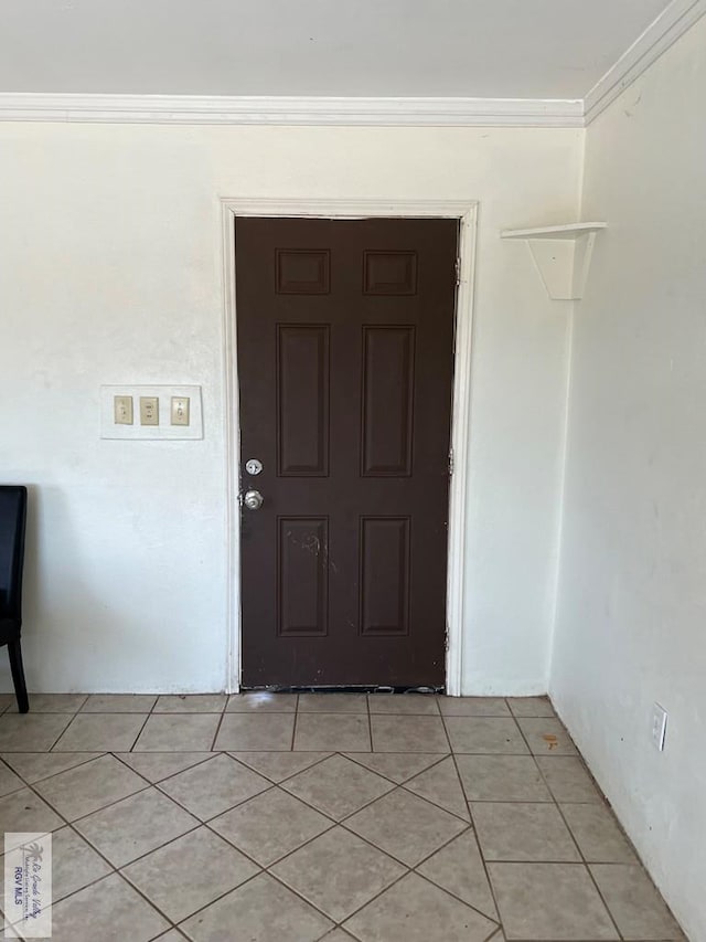 tiled entrance foyer featuring crown molding