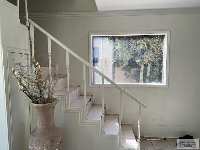 stairway featuring tile patterned flooring and ornamental molding