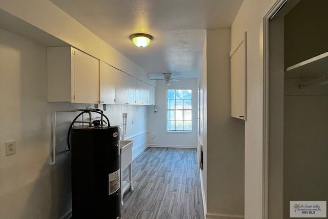 kitchen featuring white cabinets, electric water heater, light hardwood / wood-style flooring, and ceiling fan