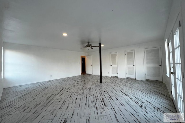 unfurnished living room with ceiling fan and light wood-type flooring