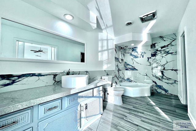 bathroom with ceiling fan, sink, hardwood / wood-style floors, a bidet, and toilet