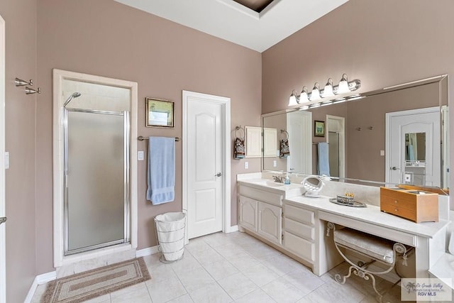 bathroom with tile patterned flooring, vanity, and walk in shower