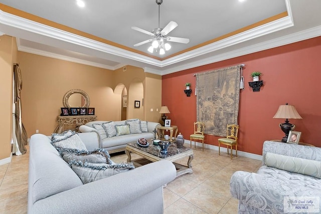 tiled living room with a tray ceiling, ceiling fan, and crown molding