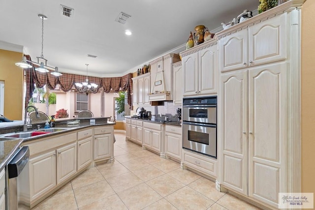 kitchen featuring appliances with stainless steel finishes, crown molding, sink, decorative light fixtures, and an inviting chandelier