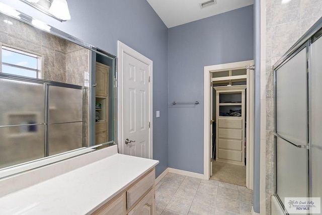 bathroom with tile patterned flooring, vanity, and shower / bath combination with glass door