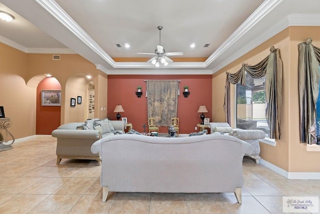 living room featuring light tile patterned floors, a raised ceiling, ceiling fan, and crown molding