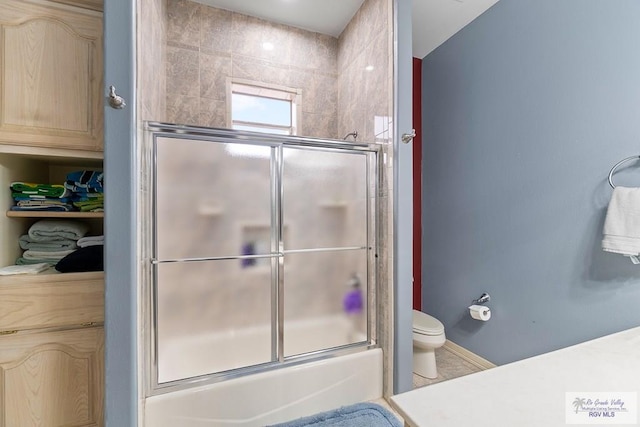 full bathroom with vanity, enclosed tub / shower combo, and toilet