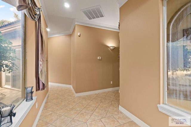 corridor featuring crown molding and light tile patterned flooring