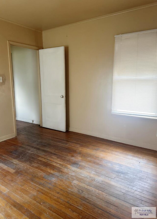 spare room with ornamental molding and hardwood / wood-style flooring