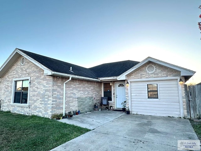 ranch-style home featuring a front lawn, fence, and brick siding