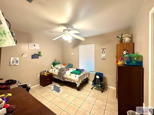 bedroom with light tile patterned floors, a ceiling fan, and baseboards