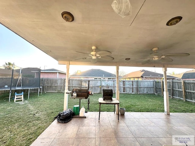 view of patio / terrace with a fenced backyard, ceiling fan, and a trampoline