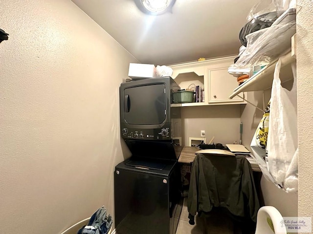 laundry area featuring cabinet space and stacked washer and dryer