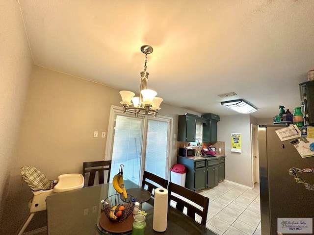 dining space featuring light tile patterned floors and a notable chandelier