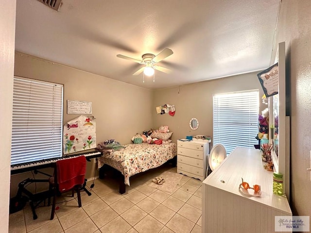 bedroom with light tile patterned floors, visible vents, and ceiling fan