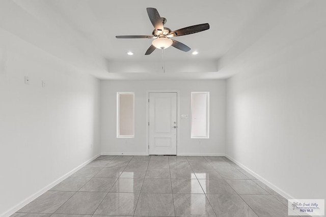 tiled spare room with ceiling fan