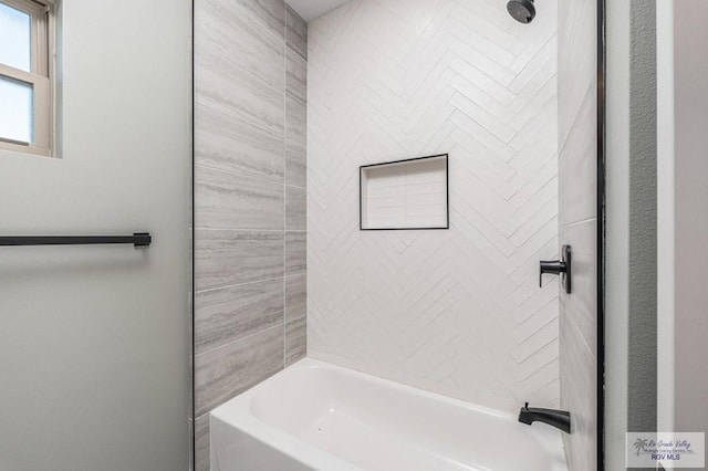 bathroom featuring tiled shower / bath