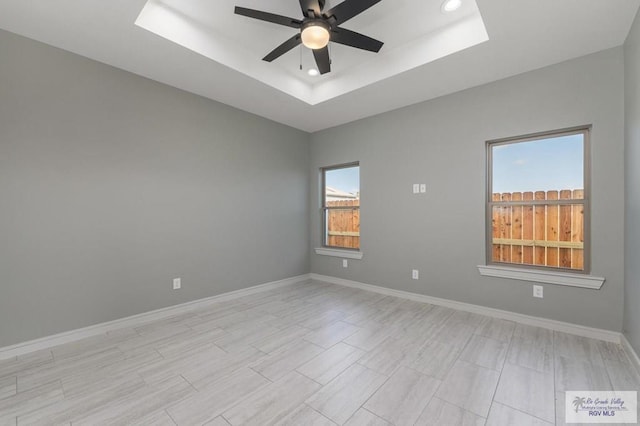 unfurnished room with a raised ceiling and ceiling fan