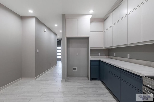 kitchen featuring blue cabinetry, white cabinets, light stone counters, and stainless steel range with electric stovetop