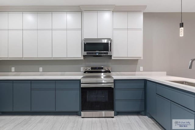 kitchen with white cabinetry, sink, stainless steel appliances, and blue cabinetry