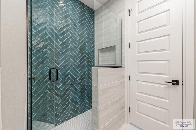 bathroom with a shower with door