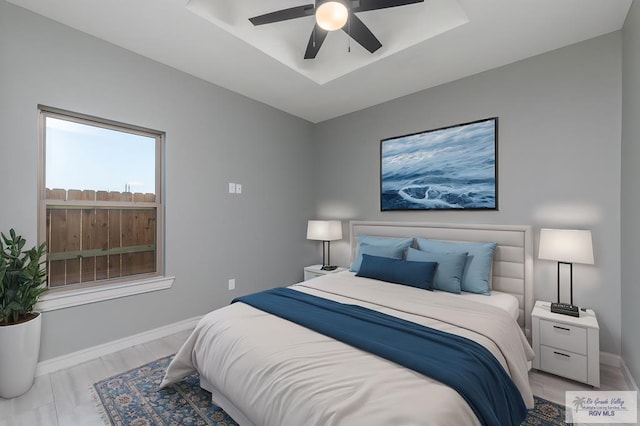 bedroom featuring a raised ceiling and ceiling fan