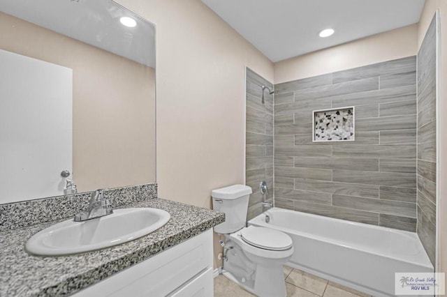 full bathroom featuring vanity, tile patterned flooring, toilet, and tiled shower / bath