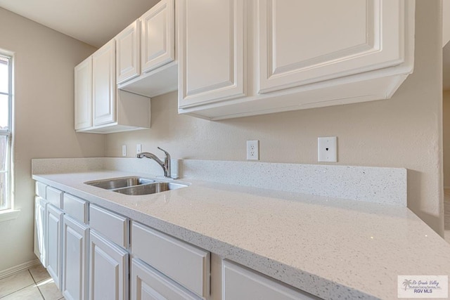2400 Firenze St, Brownsville, TX 78520 - kitchen with light stone countertops, white cabinetry, and light tile patterned floors