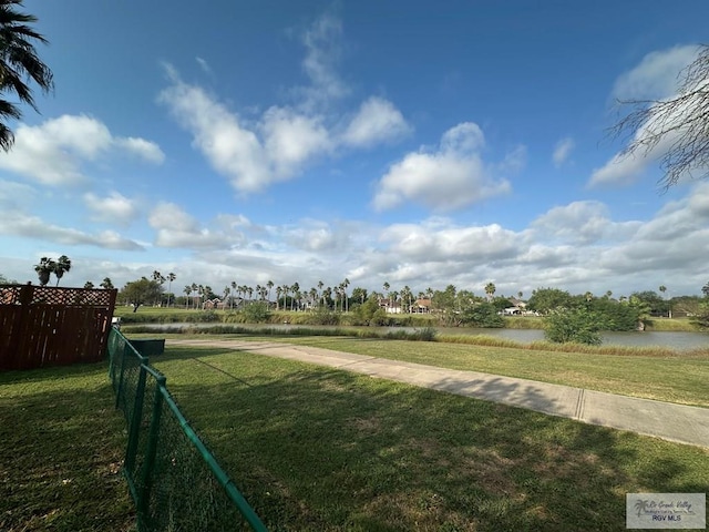 view of community with a lawn and a water view