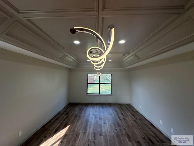 empty room featuring crown molding, dark hardwood / wood-style flooring, coffered ceiling, and a notable chandelier