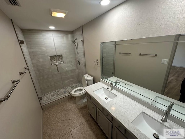 bathroom featuring walk in shower, tile patterned flooring, vanity, and toilet