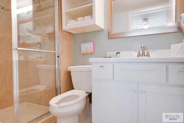 bathroom with vanity, toilet, an enclosed shower, and ceiling fan