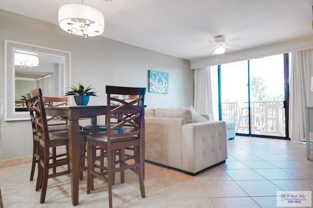 tiled dining room with ceiling fan with notable chandelier