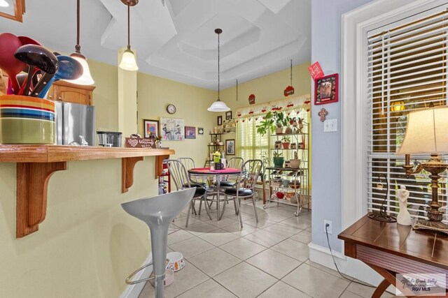 1730 Christian Cir, Harlingen, TX 78550 - kitchen featuring freestanding refrigerator, light tile patterned floors, a raised ceiling, and hanging light fixtures