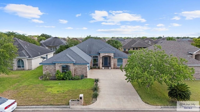 1730 Christian Cir, Harlingen, TX 78550 - french country inspired facade featuring driveway, brick siding, a front lawn, and a residential view