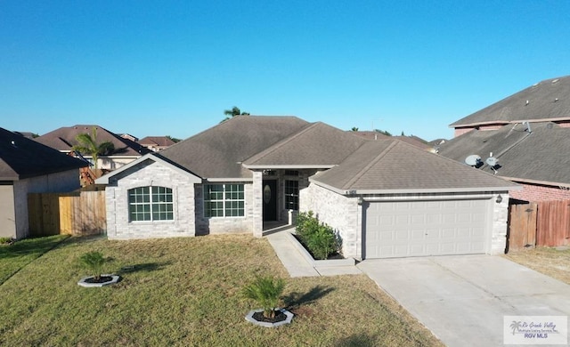 7549 Laurel Ave, Brownsville, TX 78526 - view of front facade with fence, driveway, a shingled roof, a front lawn, and a garage