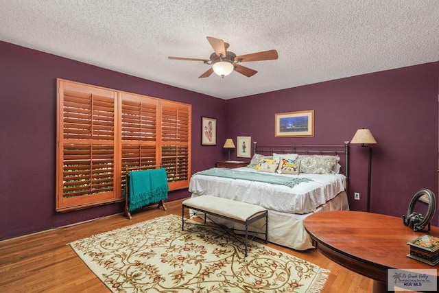 bedroom featuring ceiling fan, wood-type flooring, and a textured ceiling