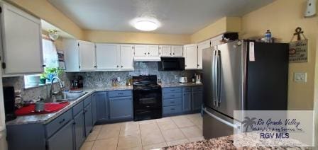 kitchen featuring black appliances, white cabinets, sink, light tile patterned floors, and tasteful backsplash