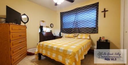 tiled bedroom featuring ceiling fan