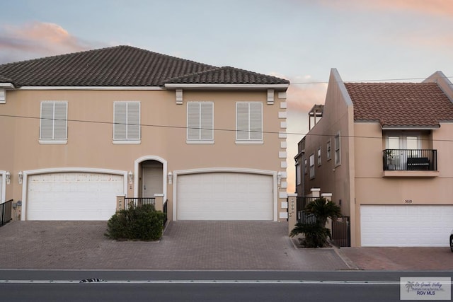 view of front of property with a tile roof, decorative driveway, and stucco siding