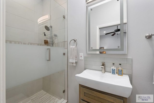 full bath with ceiling fan, a shower stall, decorative backsplash, and vanity