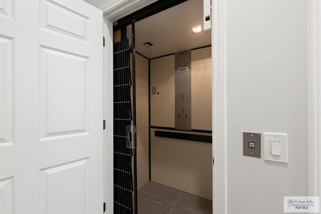 bathroom featuring elevator and tile patterned floors