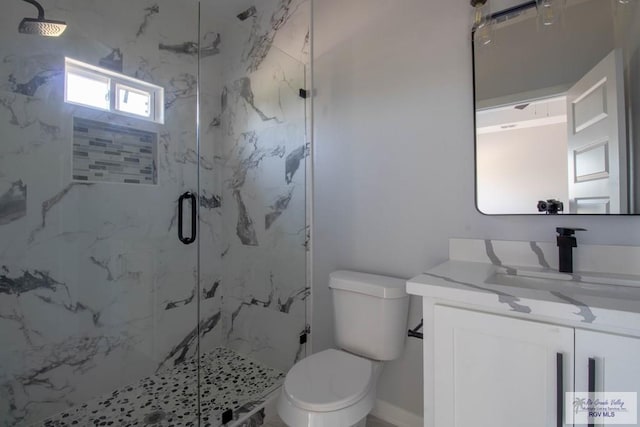 bathroom with toilet, vanity, and a marble finish shower