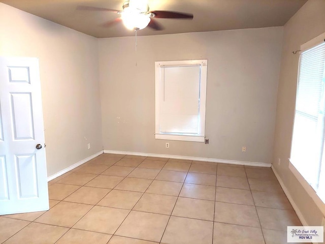 spare room featuring light tile patterned floors, baseboards, and ceiling fan
