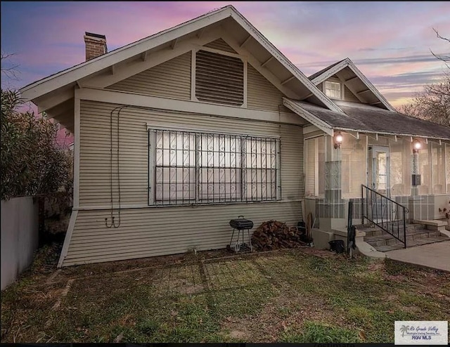 exterior space with fence, a chimney, and a front yard