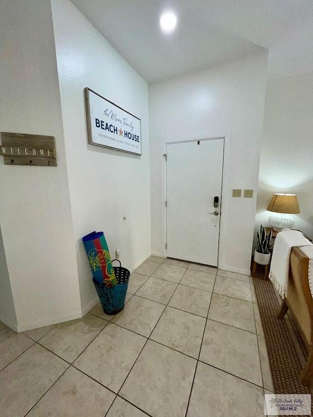 doorway featuring baseboards and light tile patterned flooring