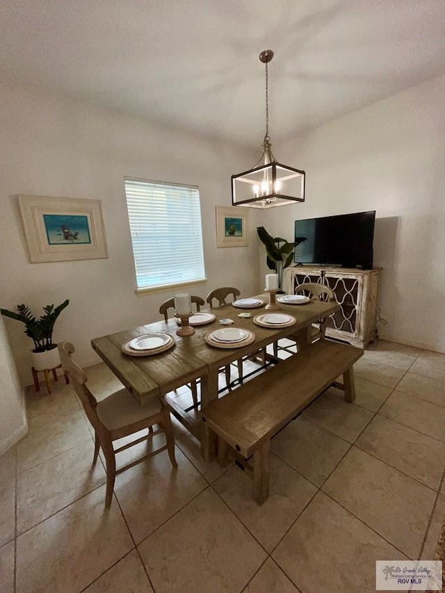 dining space with light tile patterned flooring and a notable chandelier