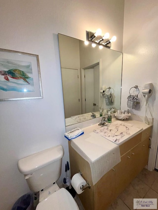 bathroom featuring tile patterned flooring, toilet, and vanity