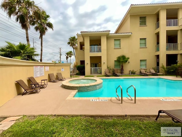 view of swimming pool with a patio area and a pool with connected hot tub