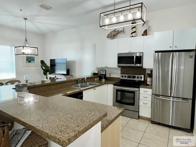 kitchen featuring visible vents, appliances with stainless steel finishes, a sink, white cabinets, and light tile patterned flooring